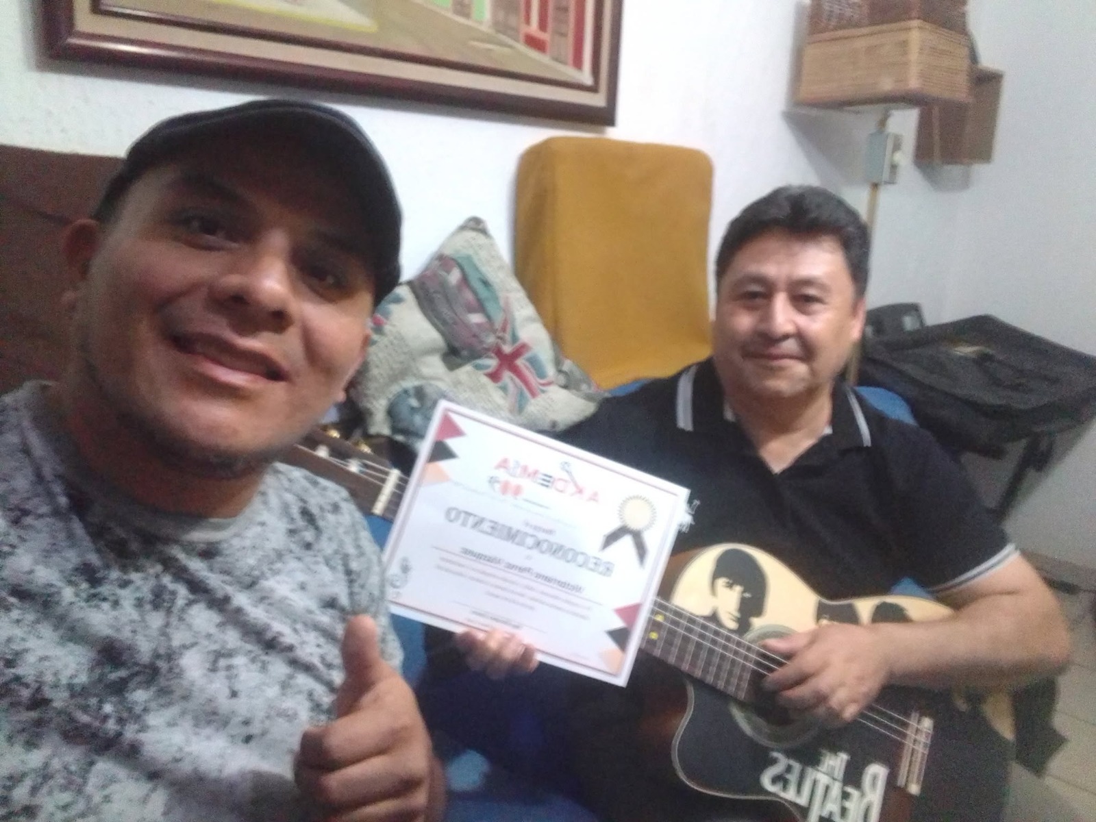 Alumno recibiendo su reconocimiento junto a su profesor en Academia 909